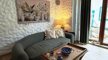 Una sala acogedora con sofá, mesa de centro y ventilador de techo.
