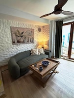 Una sala acogedora con sofá, mesa de centro y ventilador de techo.