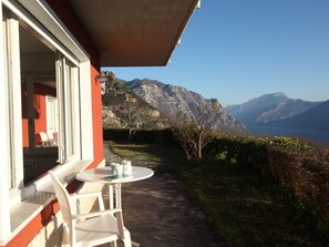 A terrace with a table and chairs, overlooking a mountainous landscape. - Holiday Apartment With 2 Bedrooms (Tremosine)