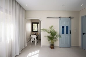A hallway with a dining area, a potted plant, and a blue door. - Enjoy at bait assel by spacey #89 (cairo)