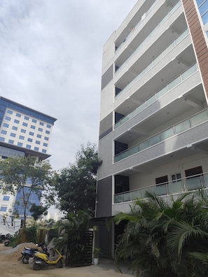 A multi-story building with balconies and a gated entrance. - Orion Signature Hotel (Hyderabad)