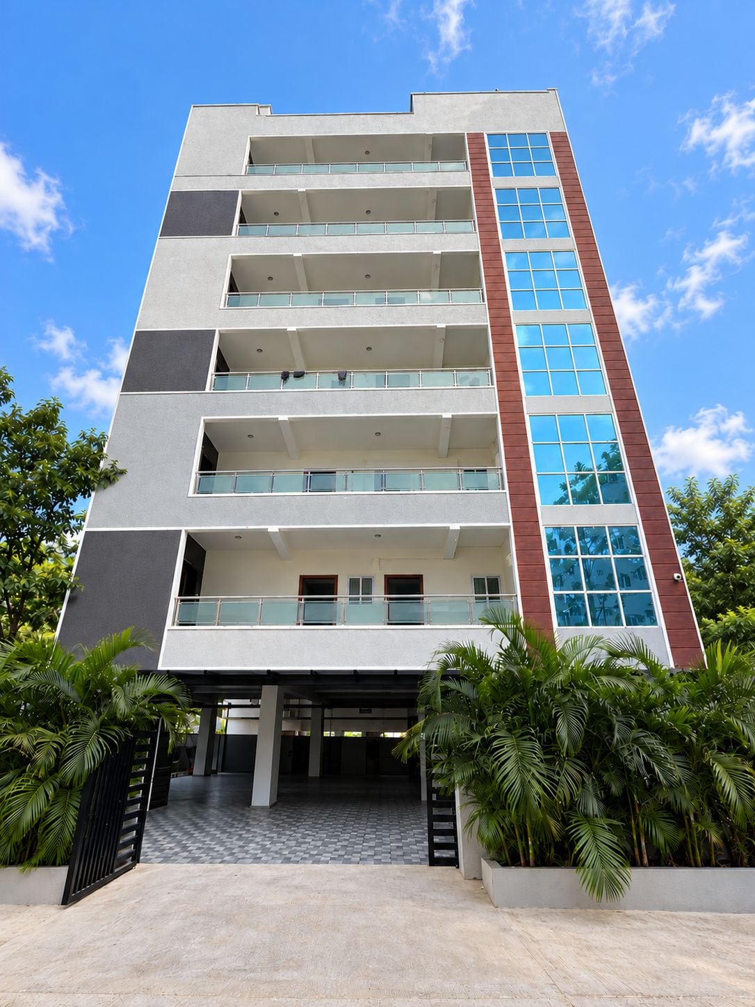 Un edificio moderno de varios pisos con balcones y grandes ventanales.