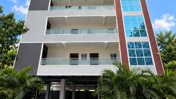 Un edificio moderno de varios pisos con balcones y grandes ventanales.