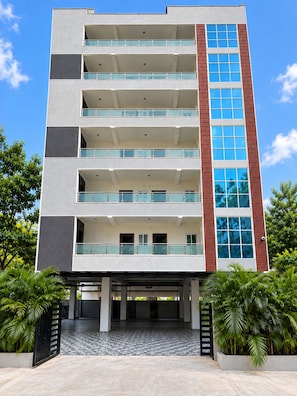 A multi-story building with a flat roof, balconies, and a checkered tile entrance. - Orion Signature Hotel (Hyderabad)