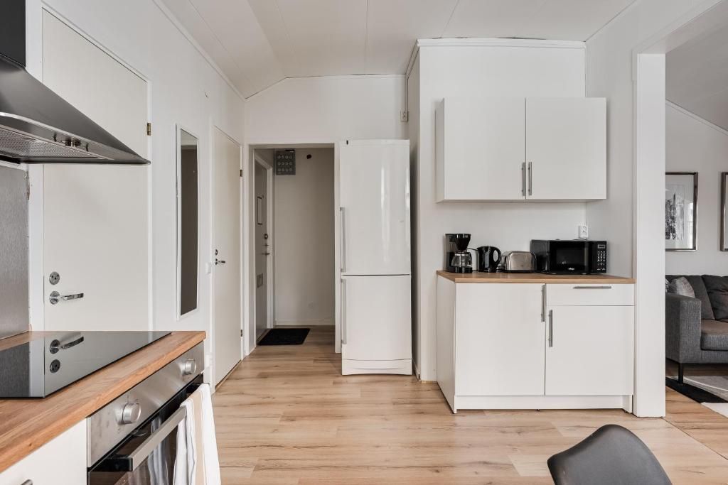 A compact kitchen with white cabinetry, a microwave, and a coffee maker on the countertop.
