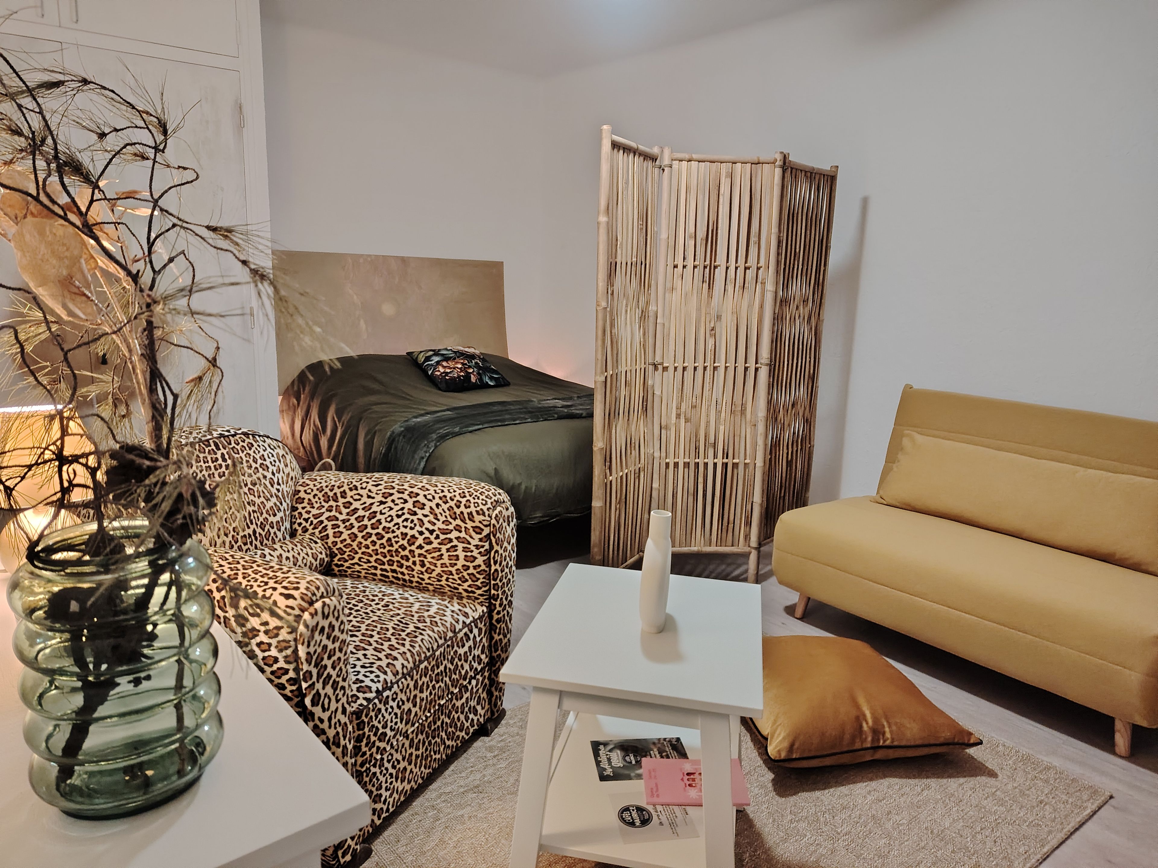 A modern living room with a sofa, a chair, a table, and a decorative plant.