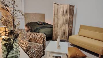A modern living room with a sofa, a chair, a table, and a decorative plant.