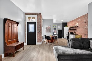 Een moderne woonruimte met een eethoek, een keuken en een zithoek met een bank en een lange zitbank.
