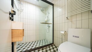 A bathroom with a shower, toilet, and a sink.