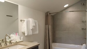Une salle de bain équipée d’un lavabo, d’un miroir et d’un espace douche.