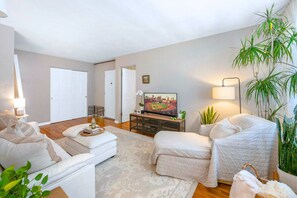 A living room with a sofa, a television, and a coffee table.