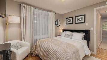 A bedroom with a bed, bedside tables, a lamp, and curtains.