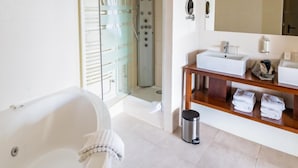 A modern bathroom with a bathtub, shower, and a vanity with a mirror and sink. - Hotel Les Dryades Golf & Spa (Pouligny-Notre-Dame)