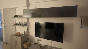A modern kitchen with a built-in TV, a microwave, and a coffee machine.