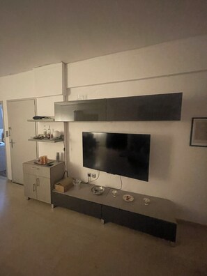 A modern kitchen with a built-in TV, a microwave, and a coffee machine.