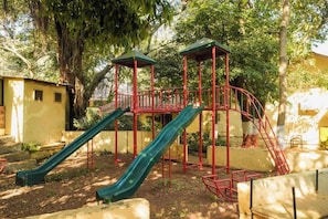 A playground with a slide and climbing structures. - Adamo Village (Karjat)