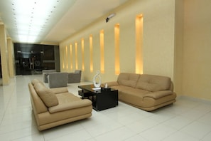 A modern living room with two sofas, a coffee table, and a wall with vertical light panels. - Raoum Inn Serviced Apartments Khafji (Al Khafji)