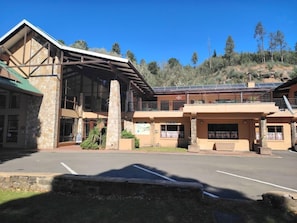 A modern building with a stone facade, large windows, and a covered entrance. - Riverbend Chalets (Drakensberg Gardens)