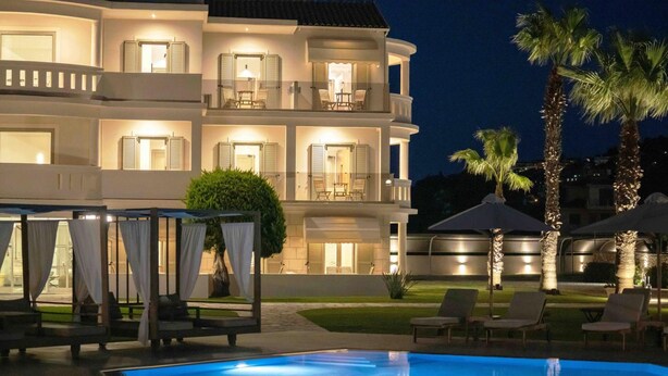 A multi-story hotel with balconies, a swimming pool, and outdoor seating. - San Giovanni Luxury Studios (Lefkada)