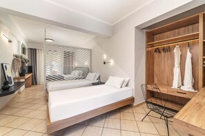 A modern bedroom with a bed, a seating area, and a wardrobe. - San Giovanni Luxury Studios (Lefkada)