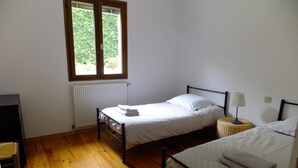 A bedroom with two beds, a radiator, a window, and a desk. - Le Clos Gentiane [vr] (Saint-Etienne)