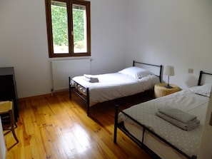 A bedroom with two beds, a radiator, a window, and a desk. - Le Clos Gentiane [vr] (Saint-Etienne)