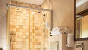 Ein modernes Badezimmer mit einer Duschkabine, einer Toilette und einem Waschbecken mit Spiegel.