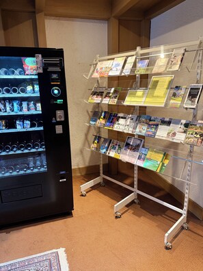Ein Getränkeautomat und ein Auslagegestell mit Broschüren.