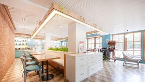 Um interior moderno com área de jantar, cozinha e espaço para sentar.
