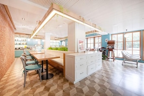 A modern interior with a dining area, kitchen, and seating space. - Capital O 631 Blooming Hill Boutique Suites (Pattaya)