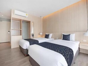 A hotel room with two beds, a wardrobe, and a bedside table. - Capital O 631 Blooming Hill Boutique Suites (Pattaya)