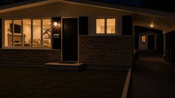 Una casa moderna con ventanas amplias, fachada de ladrillo y un acceso bien iluminado.