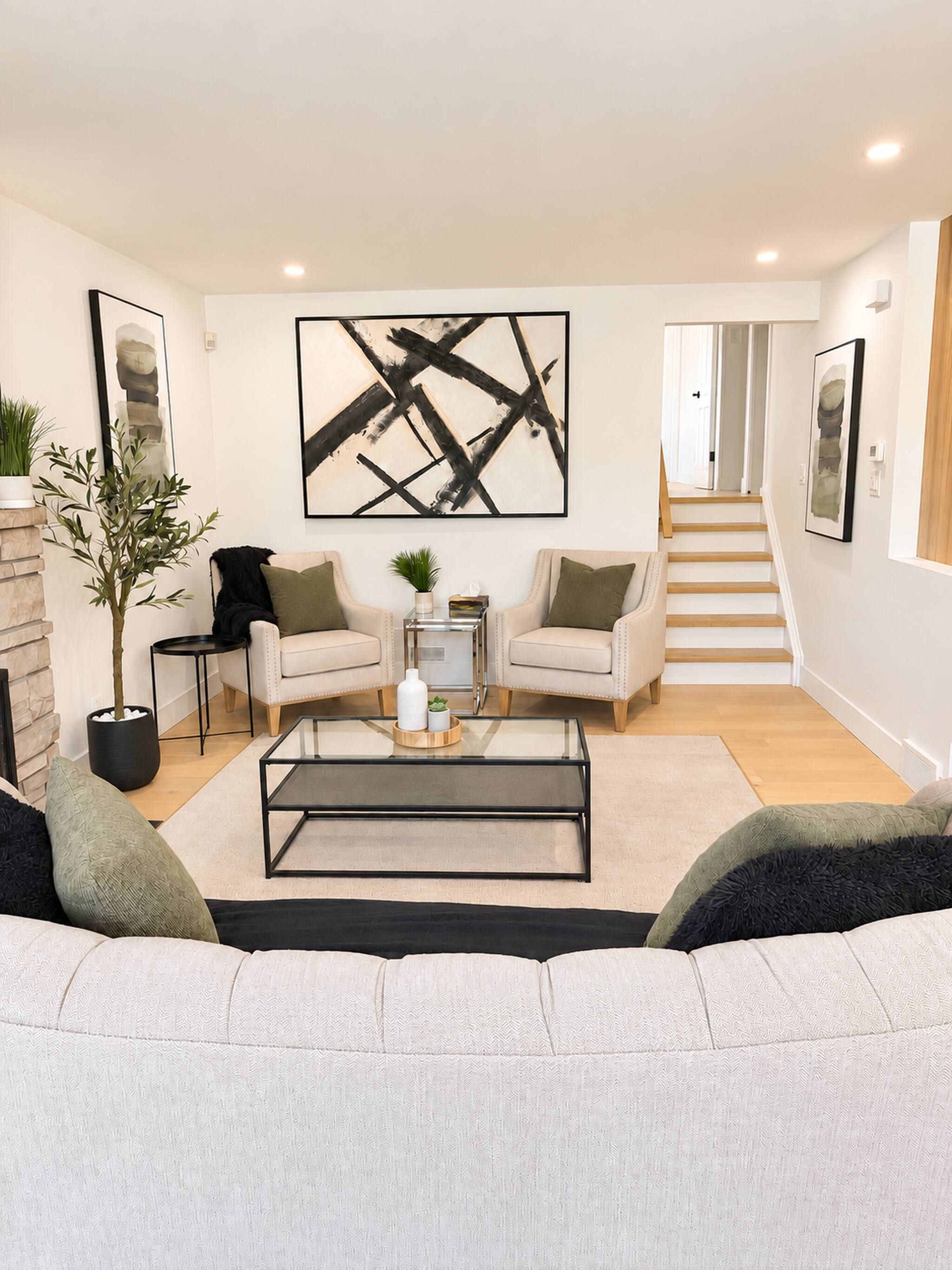 A modern living room with a sofa, coffee table, and artwork on the wall.