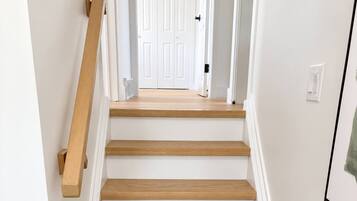 Una escalera con escalones de madera y paredes blancas.