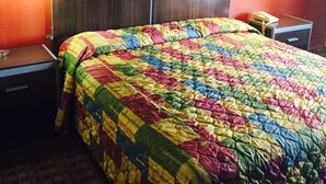 Ein Hotelzimmer mit einem großen Bett, zwei Nachttischen, einer Lampe und einem Gemälde an der Wand.