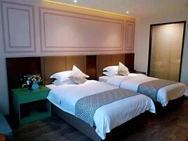 A hotel room with two beds, a nightstand, and a large wardrobe.