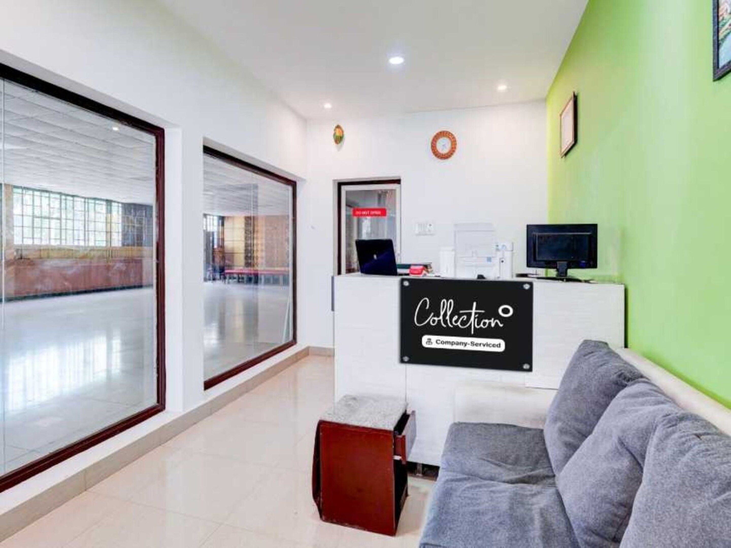 A reception area with a reception desk, a computer, and a couch.