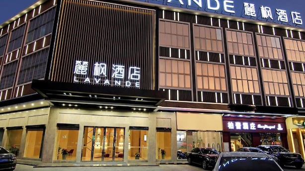Ein Hotel mit einem gut sichtbaren Schild, auf dem 'LAVANDE' und 'LAVANDE HOTEL' sowohl auf Englisch als auch Chinesisch stehen.