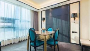 A hotel room with a dining table, four chairs, a large window with curtains, and a sliding door. - Xana Hotelle (Nanchang)