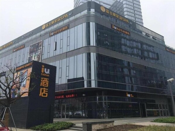 A modern hotel building with a glass facade, signage for 'iu hotel,' and a prominent entrance. - IU Hotel (Suzhou)