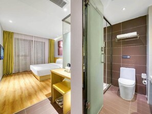 A hotel room with a bed, a desk, a shower, and a toilet. - IU Hotel (Suzhou)