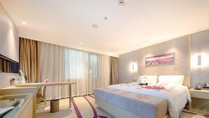 A hotel room with a bed, bedside table, desk, chair, and a large window with curtains. - Lavande Hotel (Suzhou)