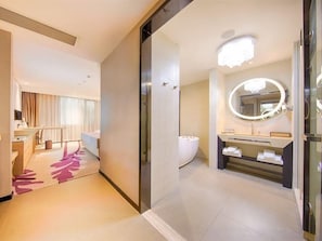 Un baño de hotel con un espejo grande, un lavabo y un inodoro.
