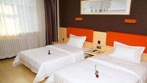 Quarto de hotel com duas camas, piso de madeira, mesa de cabeceira com telefone e um quadro na parede.