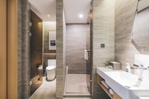 Ein modernes Badezimmer mit bodengleicher Dusche, Toilette und Waschtisch.