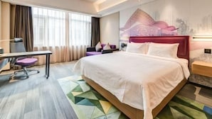 Una habitación de hotel moderna con una cama grande, un escritorio y una silla.