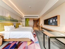 Una habitación de hotel con cama, mesitas de noche, un escritorio y una televisión.