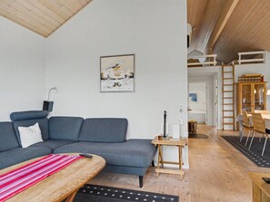 A modern living room with a grey sofa, a wooden coffee table, and a painting on the wall. - "Gunda" - 150m from the sea by Interhome (Nysted)