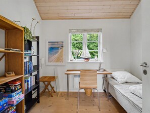 A compact room with a desk, chair, bookshelf, and a bed. - "Gunda" - 150m from the sea by Interhome (Nysted)