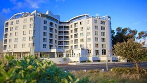 Et hotel med flere etager i moderne arkitektur, med altaner og en markant indgang.